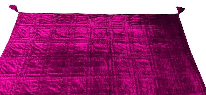 Może przedstawiać: Duży, pikowany koc w żywym kolorze magenta. Koc ma miękką, pluszową fakturę i idealnie nadaje się do dodania odrobiny koloru i ciepła do każdego pomieszczenia.