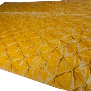 K&ouml;nnte beinhalten: Eine gelbe, gesteppte Wolldecke aus Samt mit Rautenmuster.