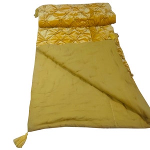 K&ouml;nnte beinhalten: Eine gesteppte gelbe Wurfdecke mit einer Samtseite und Quasten an den Ecken.