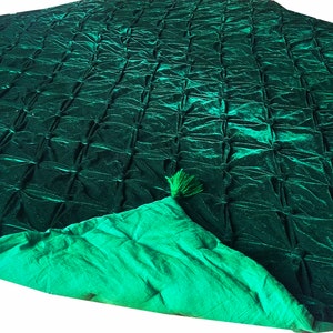 K&ouml;nnte beinhalten: Eine gr&uuml;ne, gesteppte Decke aus Samt mit gr&uuml;ner Satin-Futter und Quasten an den Ecken.