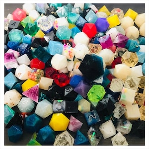 May include: A large collection of multi-sided polyhedral dice in various colors, including red, blue, yellow, green, black, white, and purple. The dice feature diverse finishes such as translucent, opaque, glitter, and marbled effects with numbers.