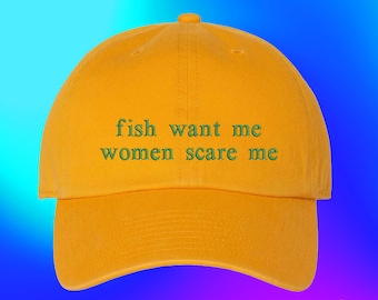 May include: A yellow baseball cap with the text "fish want me women scare me" embroidered in green on the front.