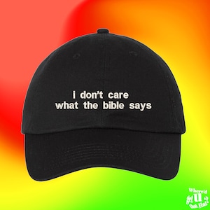 May include: Black baseball cap with white embroidered text that reads "i don't care what the bible says".