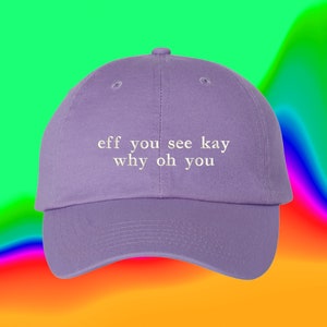 Könnte beinhalten: Lilafarbene Baseballkappe mit dem gestickten Text "eff you see kay why oh you" in Weiß.