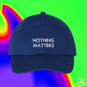 Peut inclure: Une casquette de baseball bleu marine avec un texte brodé en blanc qui dit "NOTHING MATTERS".