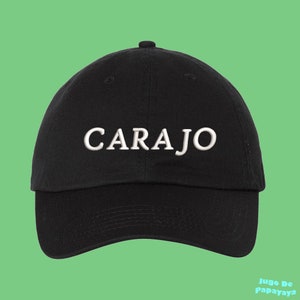 May include: A black baseball cap with the word "CARAJO" embroidered in white on the front.
