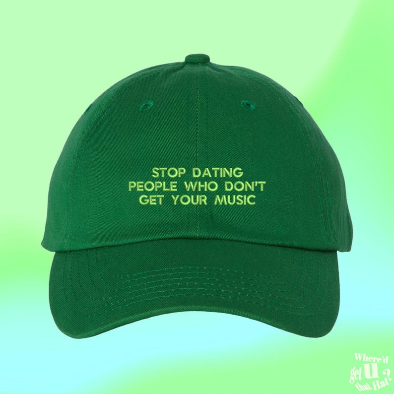 Puede incluir: Gorra de b&eacute;isbol verde con el texto "STOP DATING PEOPLE WHO DON'T GET YOUR MUSIC" en verde claro. La gorra tiene una visera curva y una corona redondeada. El fondo es un degradado de verde y verde claro.
