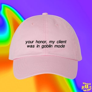 May include: Pink baseball cap with black embroidered text that reads "your honor, my client was in goblin mode".