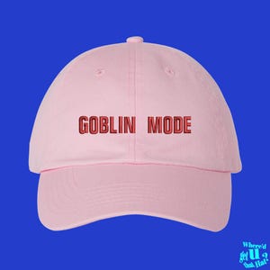 May include: A pink baseball cap with the text "GOBLIN MODE" embroidered in red on the front.