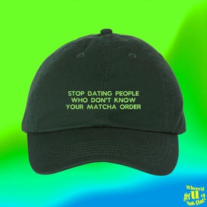 Può includere: Un cappellino da baseball verde scuro con testo ricamato in verde lime sulla parte anteriore che recita: STOP DATING PEOPLE WHO DON'T KNOW YOUR MATCHA ORDER. Il cappellino presenta una corona strutturata, una visiera curva e un bottone centrale.