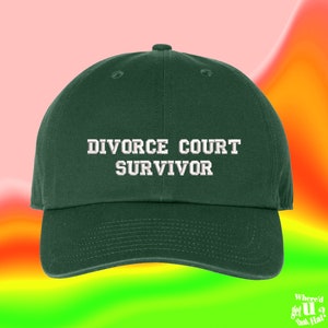 May include: A dark green baseball cap with white embroidered text that reads "Divorce Court Survivor".