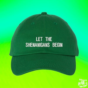 Puede incluir: Una gorra de béisbol verde con texto bordado en blanco que dice "Let the Shenanigans Begin".