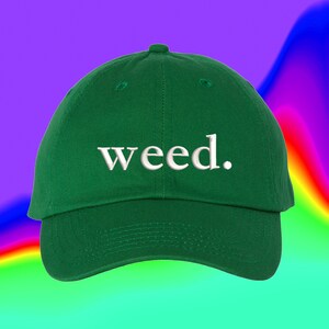 Peut inclure: Une casquette de baseball verte avec le mot "weed." brodé en blanc sur le devant.