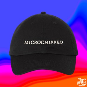 May include: A black baseball cap with the word "MICROCHIPPED" embroidered in white on the front.