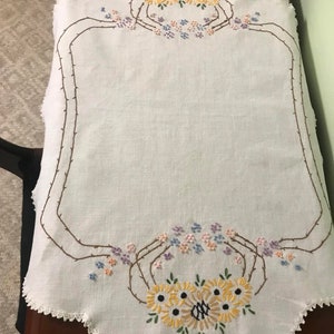 Vintage gestickter Tischläufer mit gelben, rosa und violetten Blumen.
