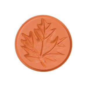 May include: A terracotta-colored cookie cutter shaped like a maple leaf.