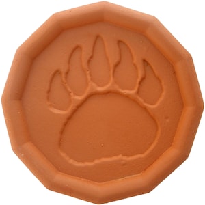 May include: Terracotta coaster with a raised bear paw print design.