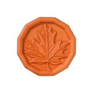 May include: An orange terracotta seal with a raised design of a maple leaf.