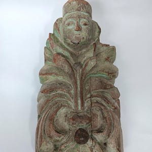 Peut inclure: Sculpture en bois sculpté d'une personne avec une couronne et un motif floral. La sculpture est peinte dans des tons de vert et de brun.