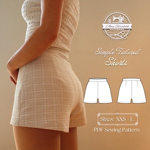 Op de afbeelding: Hoog getailleerde shorts in beige ruitpatroon en bijpassende top. De afbeelding toont het logo "Amy Elizabeth PATTERNS" en de tekst "Simple Tailored Shorts". Er zijn ook twee lijntekeningen van de shorts, samen met de tekst "Maten: XXS - L" en "PDF Sewing Pattern".