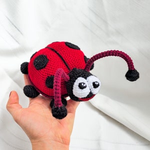 Crochet lady bug toy with black dots and antennas, baby cuddly red doll