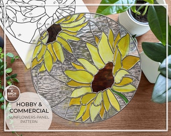 May include: A stained glass panel featuring two sunflowers with yellow petals and brown centers. The panel is round and has a silver frame. The text "HOBBY & COMMERCIAL SUNFLOWERS PANEL PATTERN" is printed below the panel.
