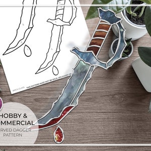 Może przedstawiać: Wzór witrażu do zakrzywionego sztyletu w czerwono-niebiesko-brązowej kolorystyce. Wzór zawiera kroplę krwi na czubku sztyletu. Tekst "HOBBY & COMMERCIAL CURVED DAGGER PATTERN" jest widoczny na dole obrazu.
