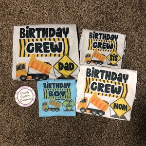 May include: Four white t-shirts with a construction theme. The shirts say "Birthday Crew" with a yellow dump truck graphic. One shirt says "Dad", one says "Mom", one says "Sis", and one says "Birthday Boy" with the number 2.