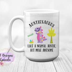May include: White ceramic mug featuring a purple dinosaur illustration and the text "Auntiesaurus Like a normal auntie, but more awesome".