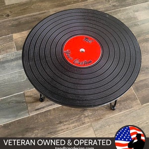 May include: A black vinyl record coffee table with a red center label that says "Text Your Custom". The table is on a wood floor.