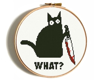 Può includere: Ricamo a punto croce in un telaio di legno con un gatto nero che tiene un coltello insanguinato. Il testo "WHAT?" è ricamato sotto. Lo sfondo è bianco con un motivo a griglia.