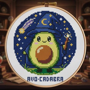 Pode incluir: Bordado em ponto cruz de um abacate mágico com chapéu e túnica azuis, segurando uma varinha. O abacate tem um caroço castanho e é rodeado por um céu estrelado. O texto "AVO-CADABRA" está na parte inferior, num bastidor.
