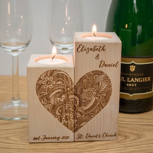 Könnte beinhalten: Zwei Kerzenhalter aus Holz mit einem Herzdesign und dem Text "Elizabeth & Daniel" und "2nd January 2020 St. David's Church".