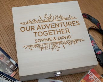 May include: A wooden box with a hinged lid, engraved with the words "Our Adventures Together" and the names "Sophie & David". The box is decorated with a floral design.