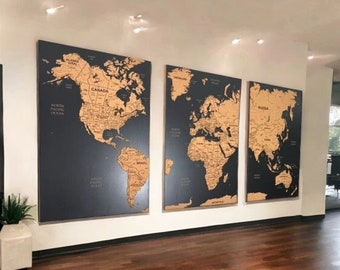 May include: Three world maps on a black background with gold-coloured continents and country borders. The maps are framed and hung on a white wall.