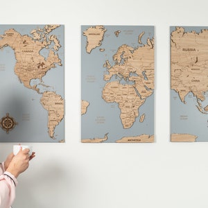 以下が含まれることがあります： 薄い灰色の背景に、木製の地球儀が3つ並んでいます。地図は3つのセクションに分かれており、北アメリカ、ヨーロッパとアフリカ、アジアとオーストラリアです。各セクションには大陸の名前が書かれています。