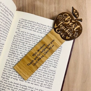 May include: Wooden bookmark shaped like an apple with the text "Best Teacher Ever" engraved on it. The bookmark is personalized with the text "Miss Jacobson Thank you for helping me grow Love Mikey, Class 4U xx".