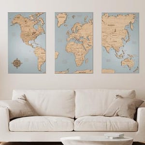 May include: Three wooden world maps with a light blue background. The maps are mounted on a white wall above a white couch. The maps are divided into three sections: North America, Europe and Africa, and Asia and Australia.