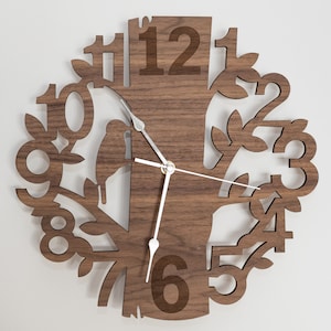 May include: A wooden wall clock shaped like a tree with the numbers 1 through 12 displayed on the branches. The clock has a brown wood finish and silver hands.