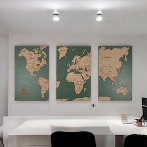 以下が含まれることがあります： 緑色の背景と茶色の大陸を持つ木製の地球儀が3つあります。地図は、モダンなオフィス設定の白い壁に取り付けられています。
