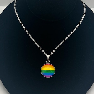 May include: A silver chain necklace with a round pendant featuring the rainbow pride flag.