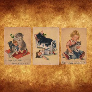 Un set di 3 splendide cartoline antiche dei primi anni del 1900 raffiguranti gatti, gattini, bambole e una bambina, probabilmente provenienti dalla Germania.