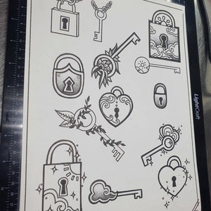 May include: A black and white illustration of various lock and key designs. The designs include a heart-shaped lock, a padlock with a chain, a key with a flower design, and a key with a cloud design. The illustration is signed "Psykyi".