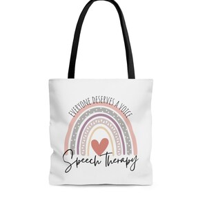 May include: White tote bag with black handles featuring a rainbow with a heart in the center and the text "Everyone deserves a voice Speech Therapy".