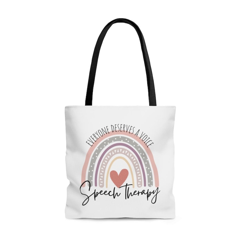 May include: White tote bag with black handles featuring a rainbow with a heart in the center and the text "Everyone deserves a voice Speech Therapy".