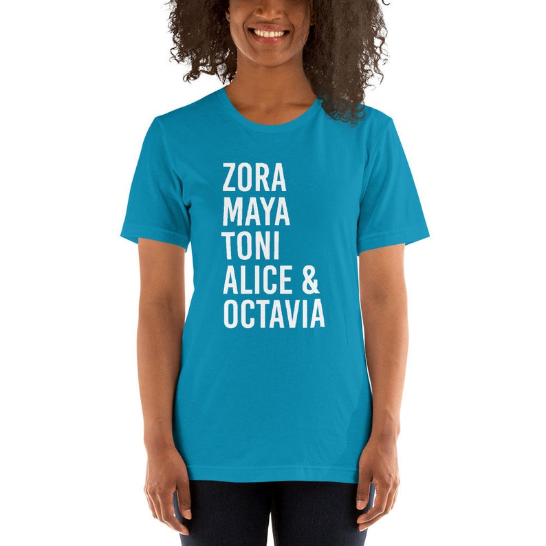 May include: A turquoise blue t-shirt with white text that reads "Zora Maya Toni Alice & Octavia".