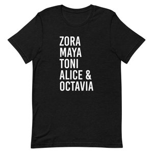 May include: Black t-shirt with white text that reads "Zora Maya Toni Alice & Octavia"