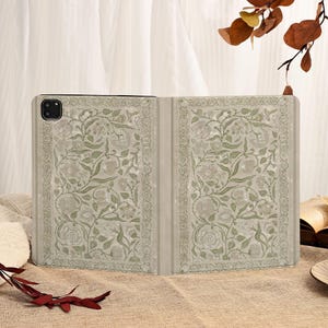 May include: A light beige tablet case with a floral design in shades of green and gray. The case is open, revealing the interior with a matching pattern. The design features roses and leaves.