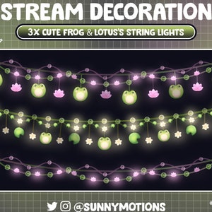 Puede incluir: Tres juegos de luces de cadena con ranas verdes y flores de loto rosas colgando de ellas. Las luces son blancas y el fondo es una cuadrícula verde.