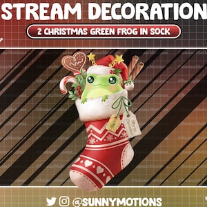 May include: A green frog wearing a Santa hat is peeking out of a red and white Christmas stocking filled with candy canes, gingerbread cookies, and cinnamon sticks. The stocking has a tag that says "Merry Christmas".